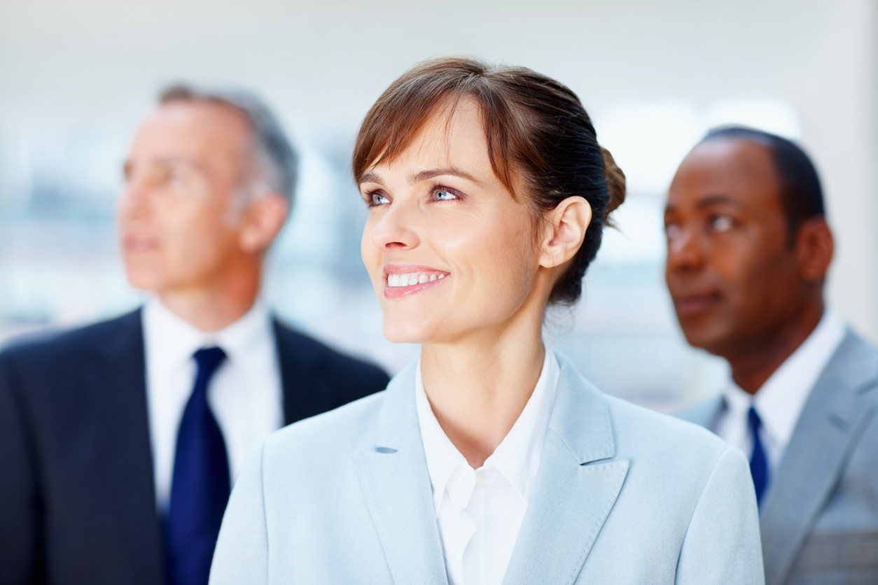 Focus on business woman with colleagues in distance